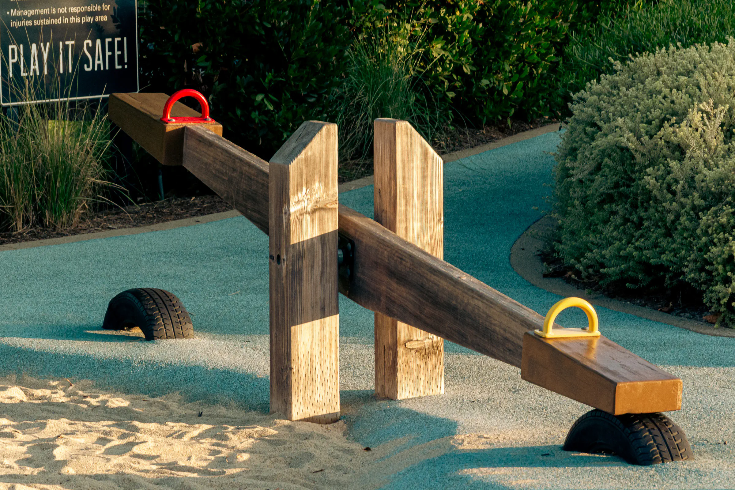 Playground seesaws in afternoon light